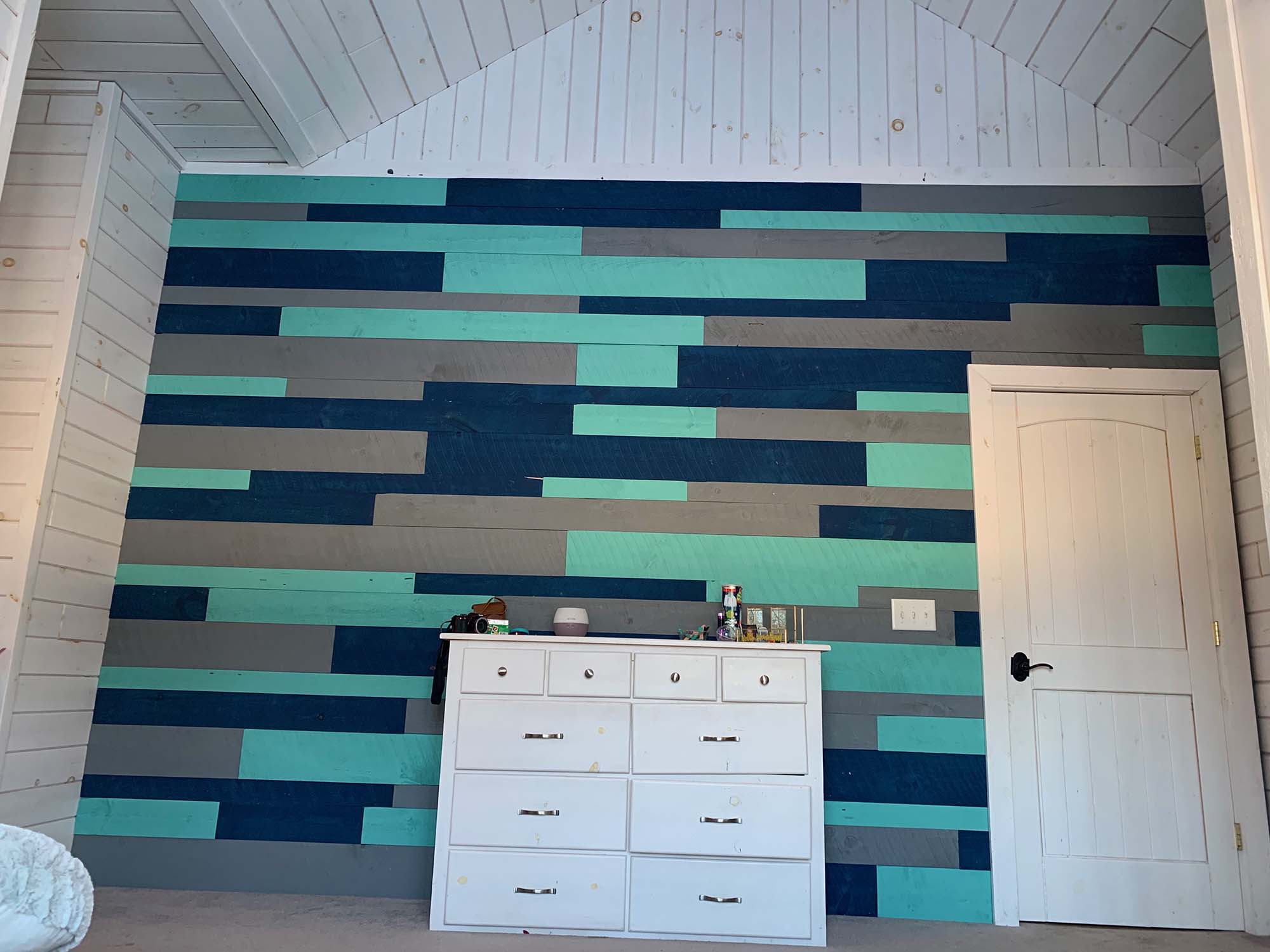 Wood paneling painted in blue, grey, and aqua.
