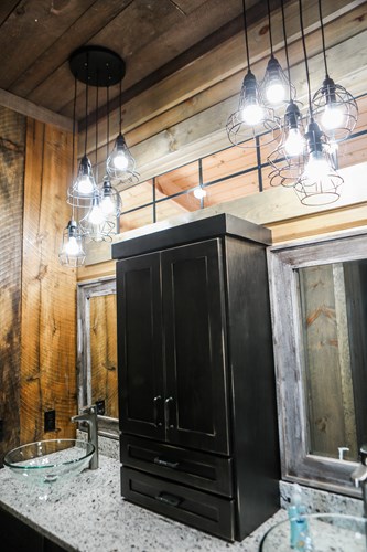 Lake house bathroom countertop with double vessel sink and barn wood siding.