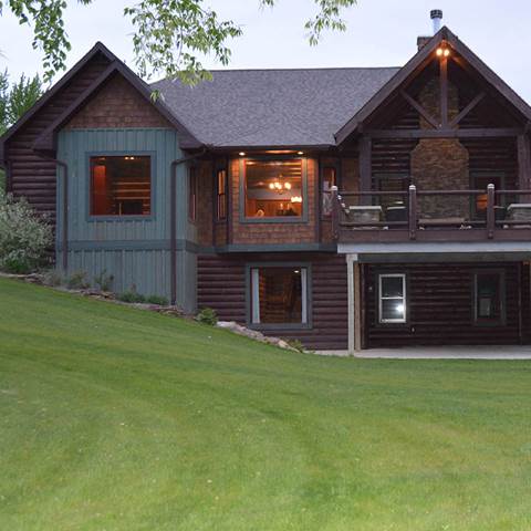 Log home with log siding and dark oak cedar shake panels.