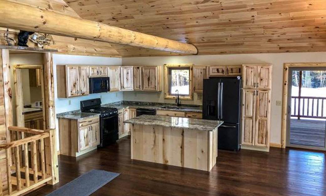 a traditional log cabin kitchen with pine beams