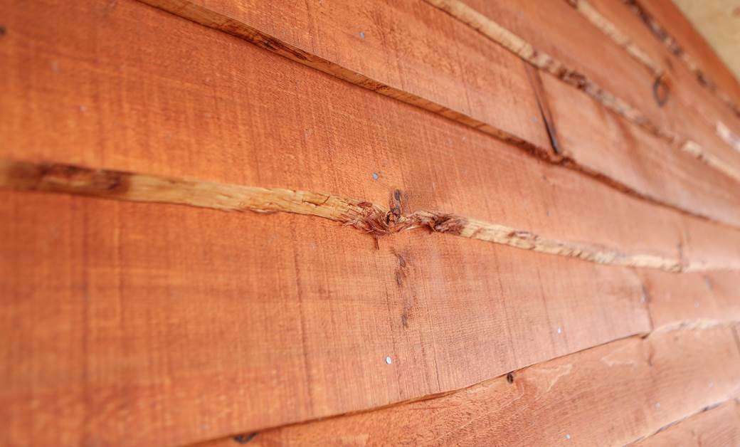 Close up of wavy edge siding, pre-stained Ember.