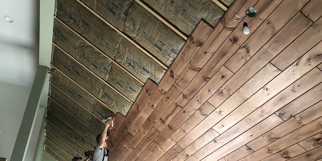 Installing 1x8 tongue and groove pine paneling with a gunstock pre-stain.
